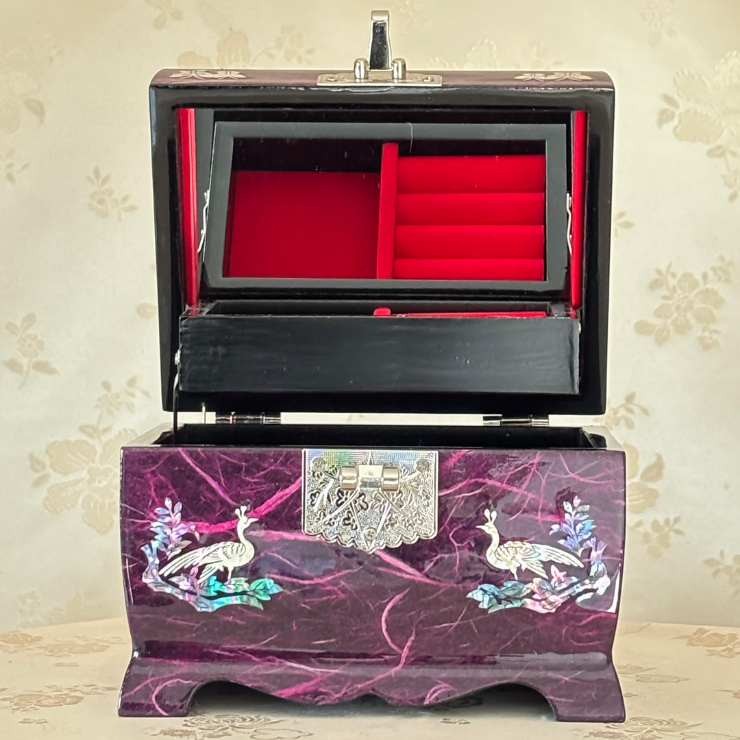Jewelry box with peacock design on a floral wallpaper background