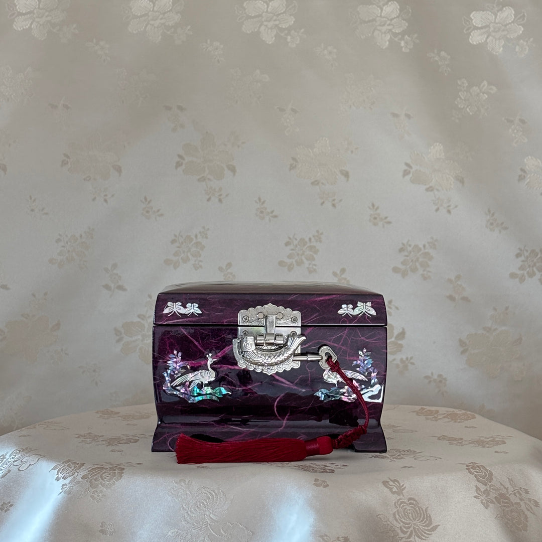 Decorative purple jewelry box with floral patterns on a floral-patterned surface