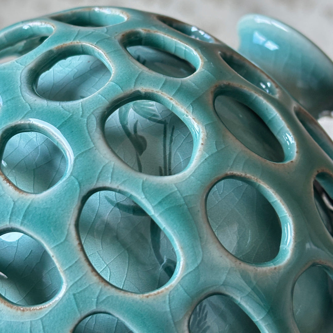 Close-up of a ceramic vase with circular holes