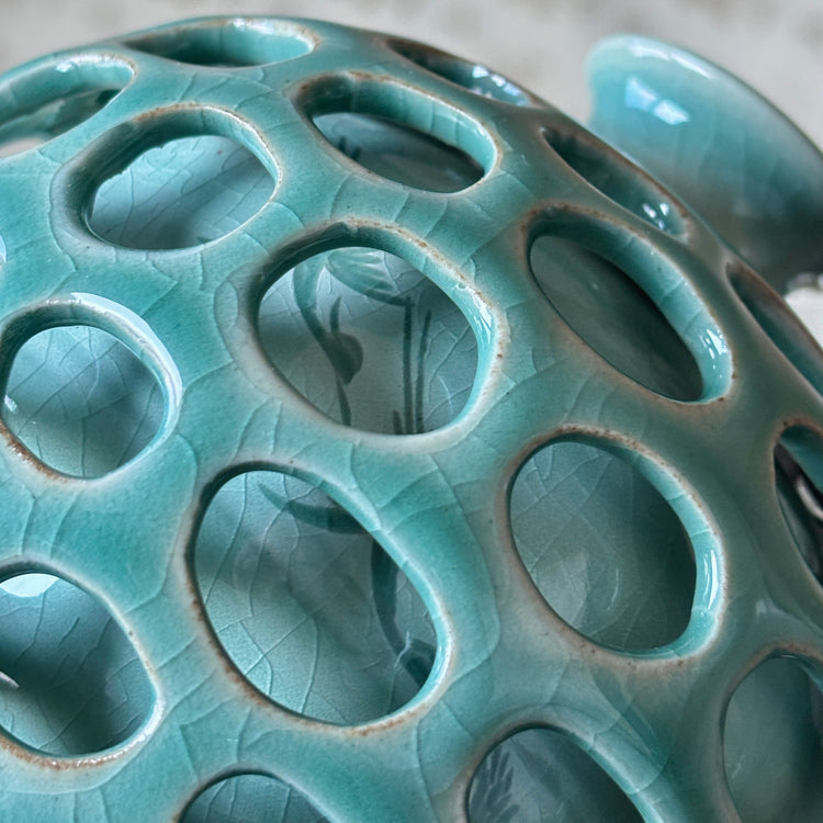 Close-up of a ceramic vase with circular holes