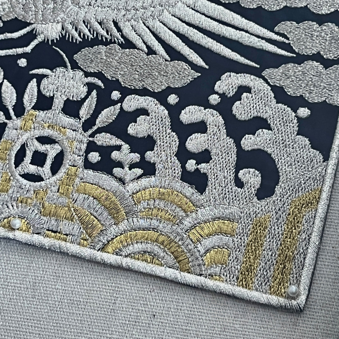 Close-up of an embroidered fabric with intricate patterns on a gray background