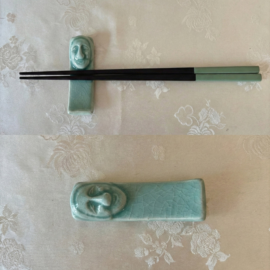 ceramic chopstick rest with face design on a floral-patterned tablecloth