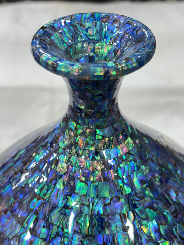 Close-up of a colorful, iridescent vase on a white background