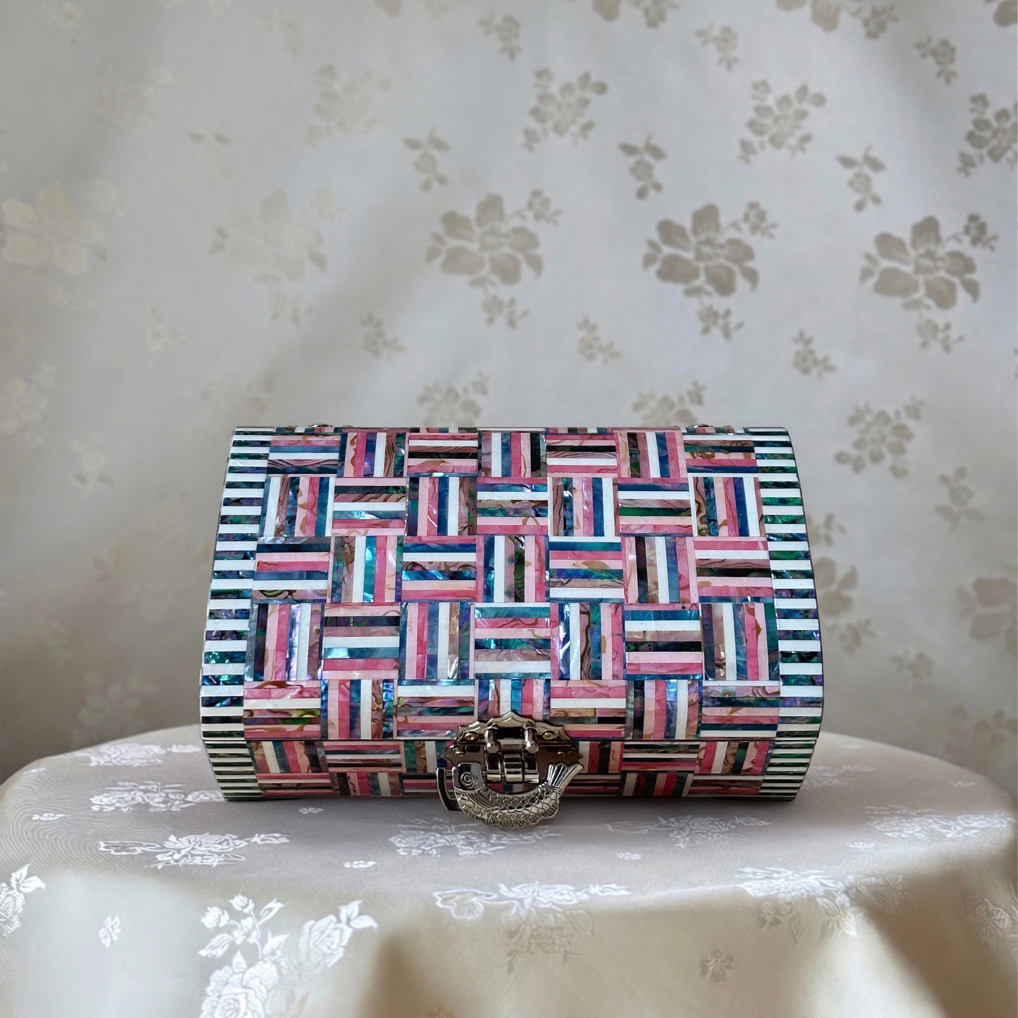 Multicolored geometric patterned handbag on a floral-patterned surface