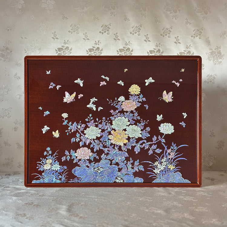 Decorative wooden panel with floral and butterfly design on a textured wall background