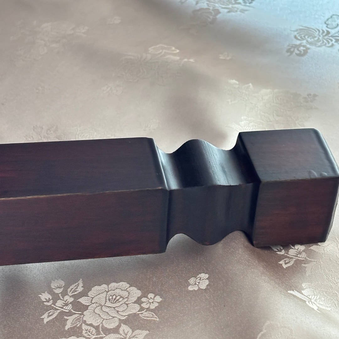 Wooden table leg with a floral patterned fabric background