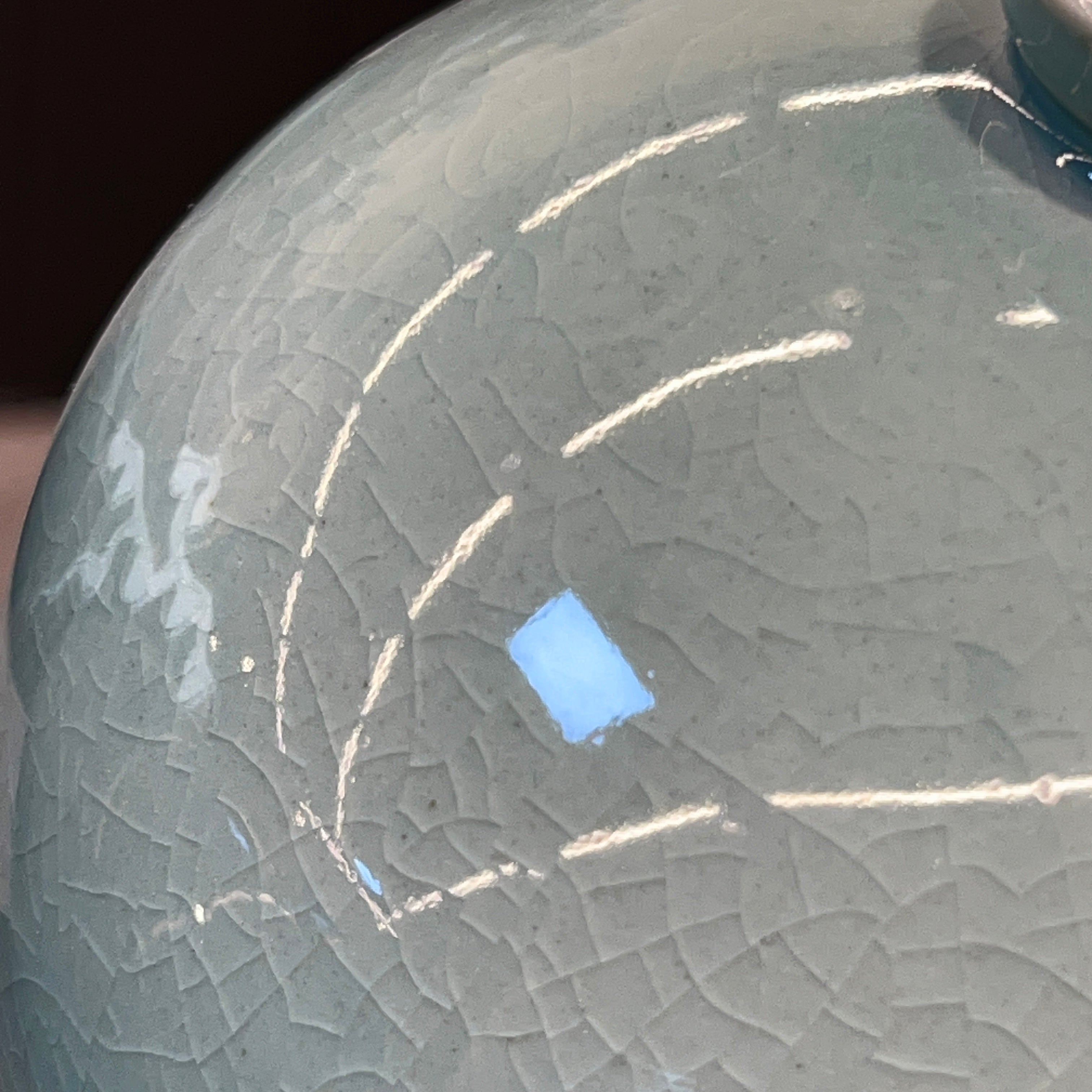 Close-up of a textured cracked celadon surface 
