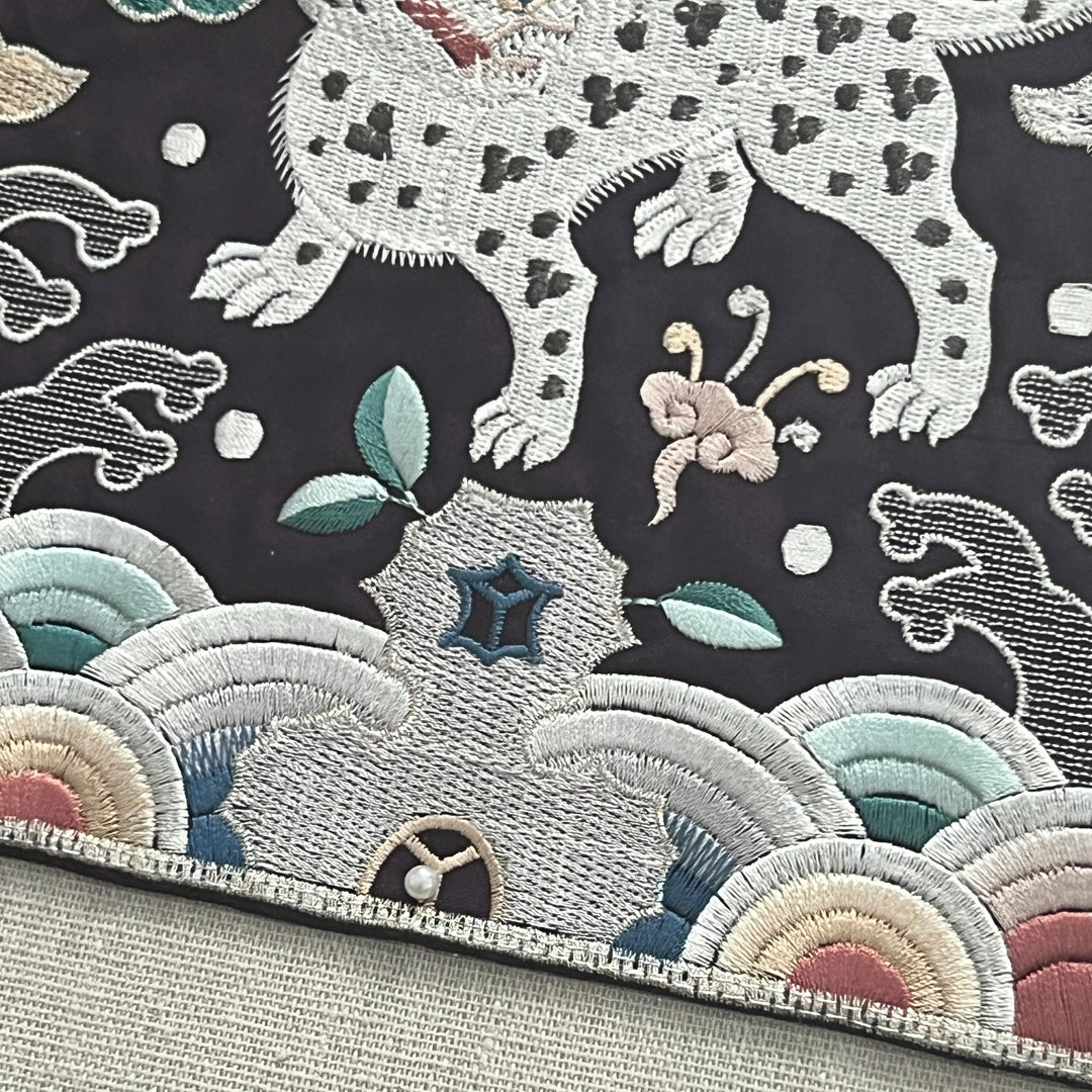Embroidered fabric with a tiger design on a dark background