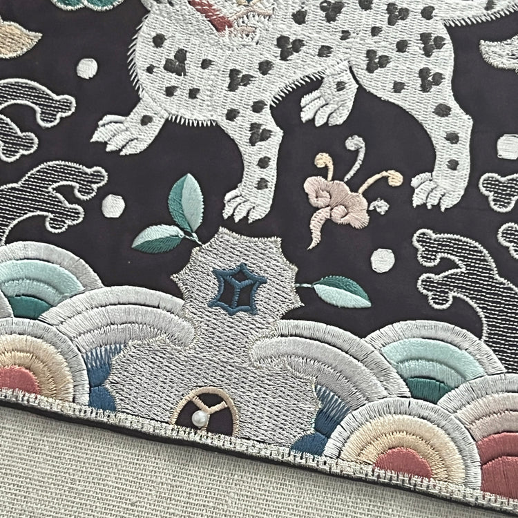 Embroidered fabric with a tiger design on a dark background