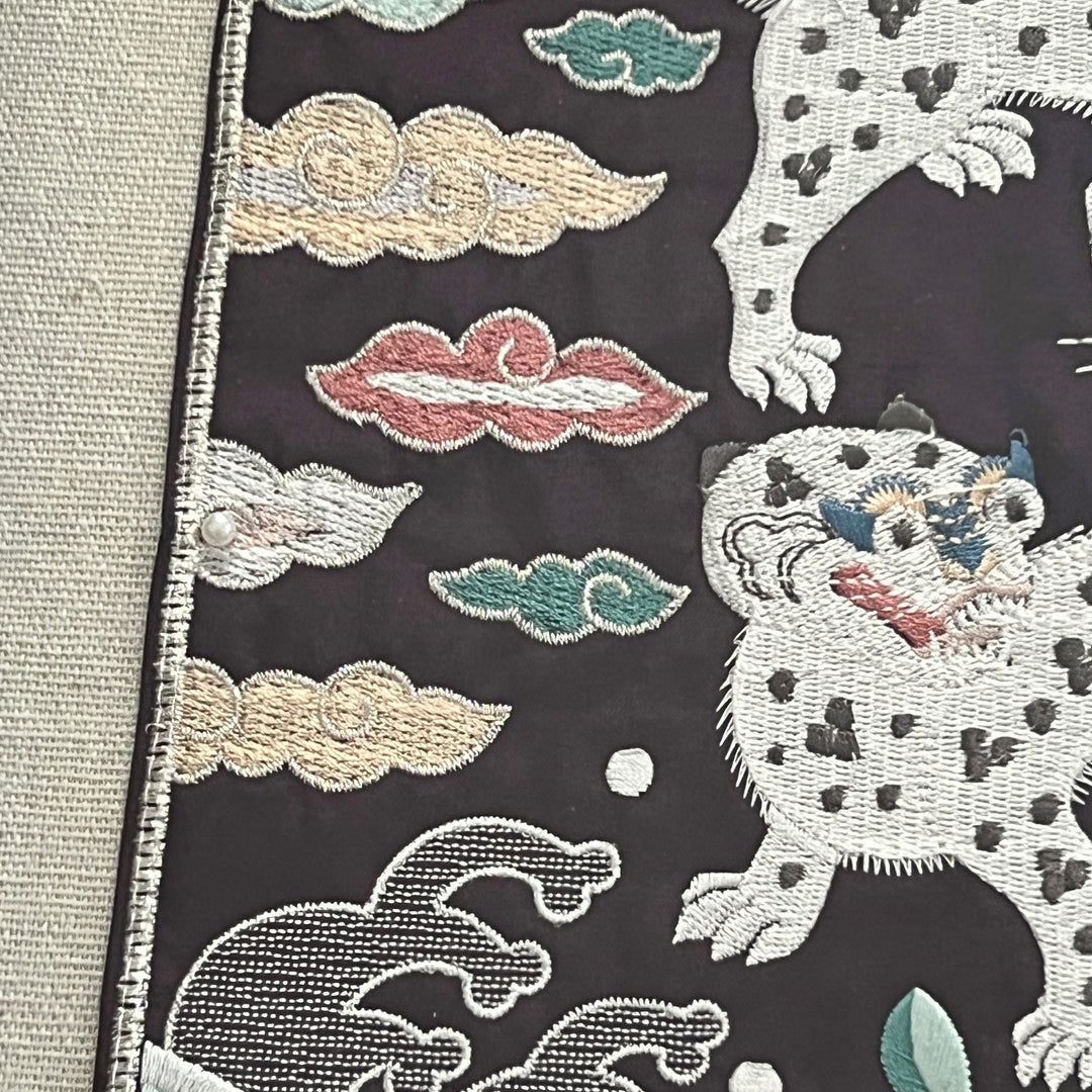 Embroidered fabric with tigers and clouds on a dark background
