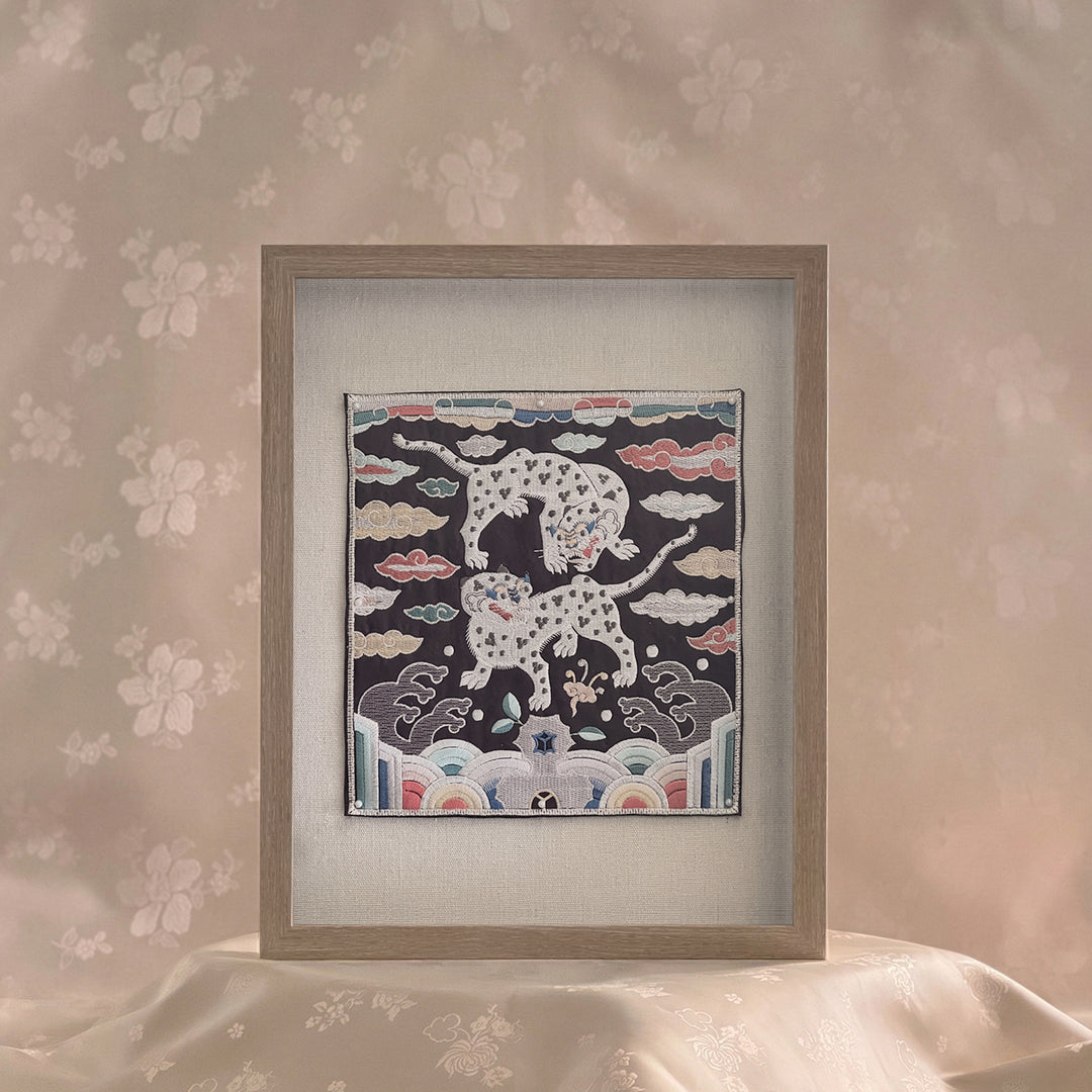 Framed artwork with a design of leopards on a floral wall background