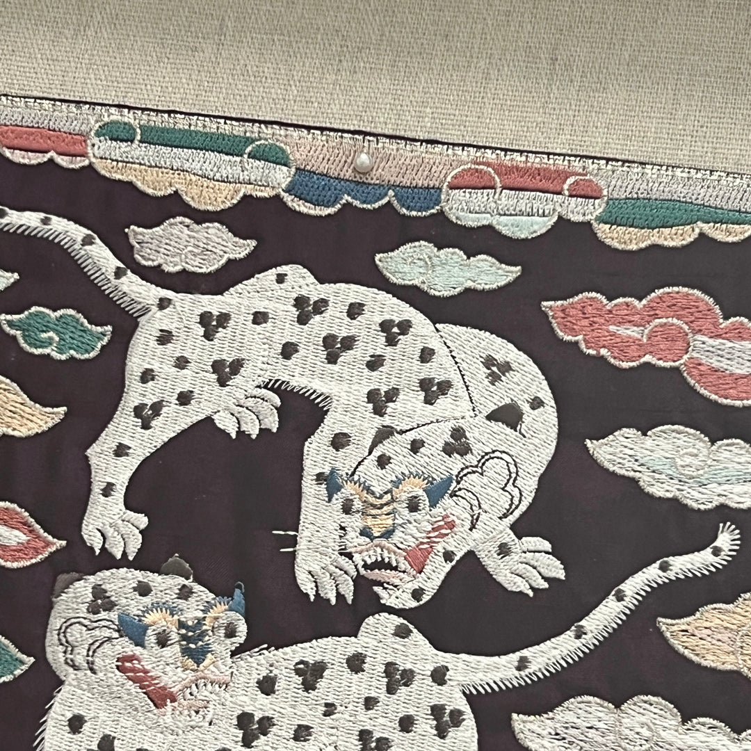 Embroidered design of leopards and clouds on a dark background