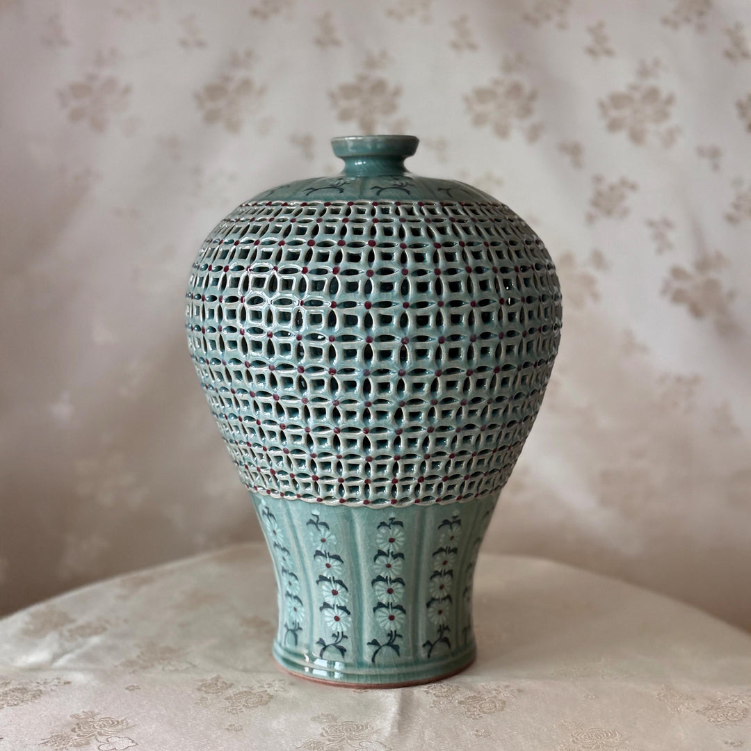 Decorative ceramic vase with textured design on a floral-patterned surface