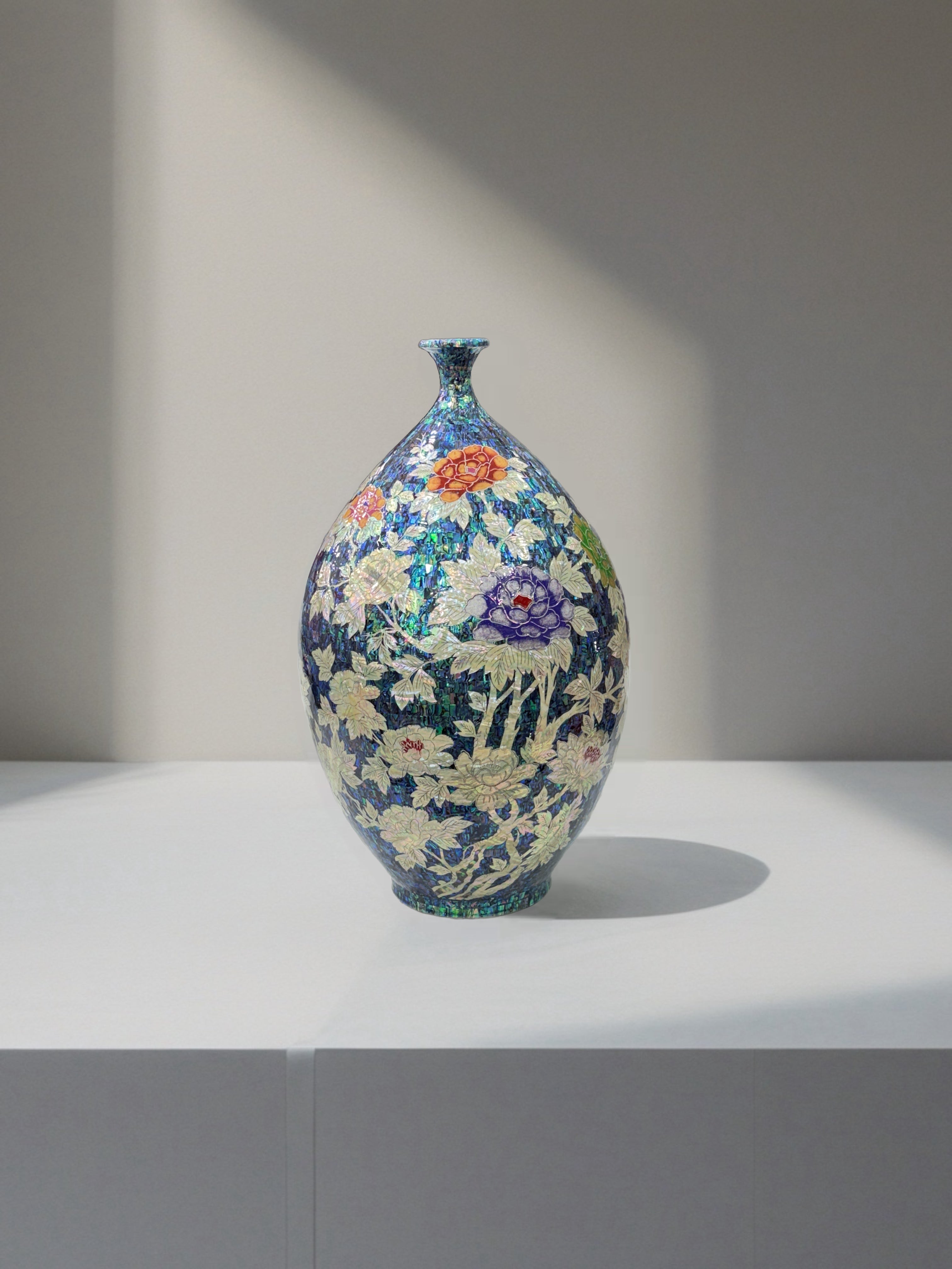 korean vase with floral patterns on a white surface and gray background