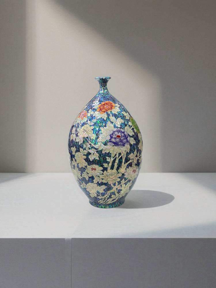 korean vase with floral patterns on a white surface and gray background