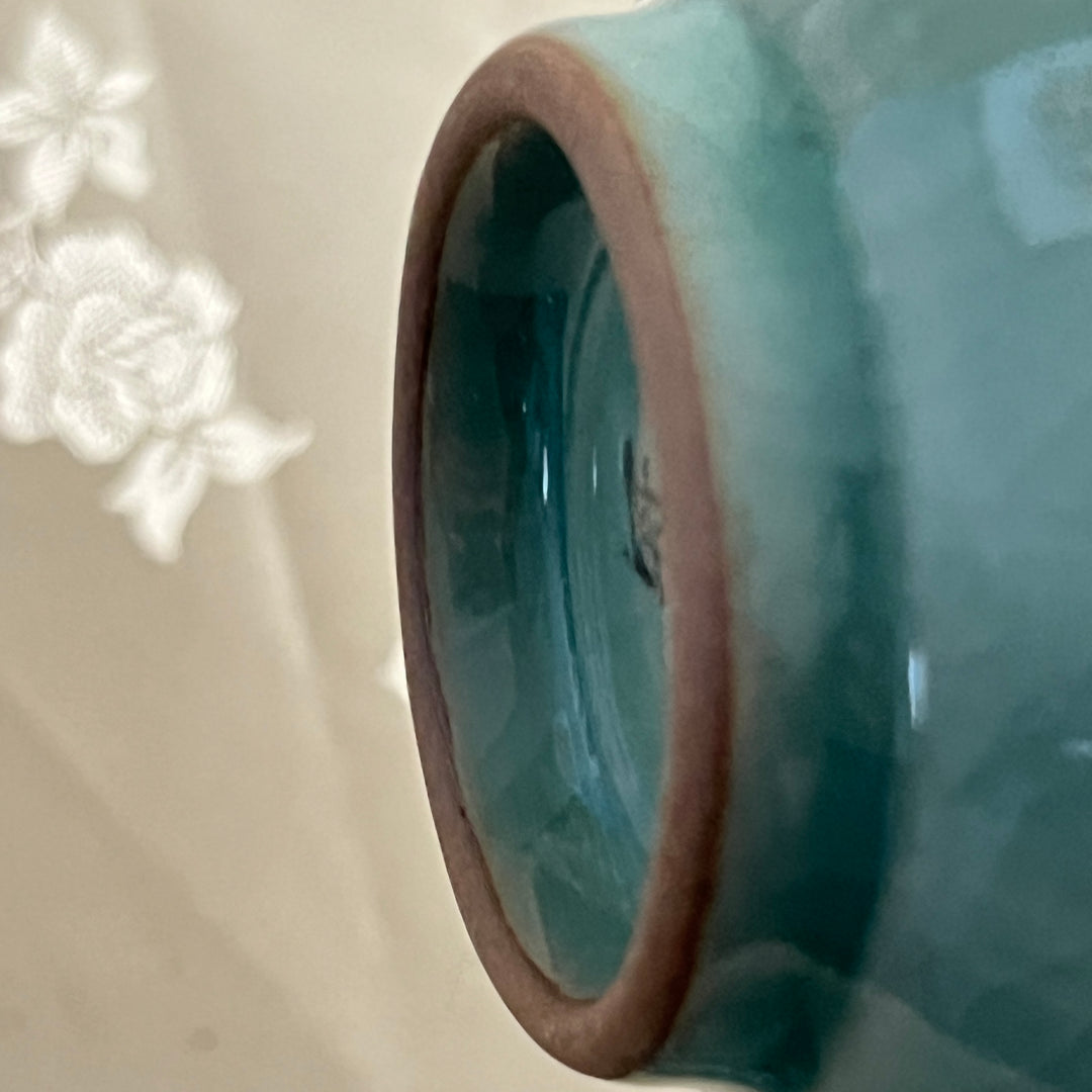 Close-up of a ceramic vase with a textured surface on a light background