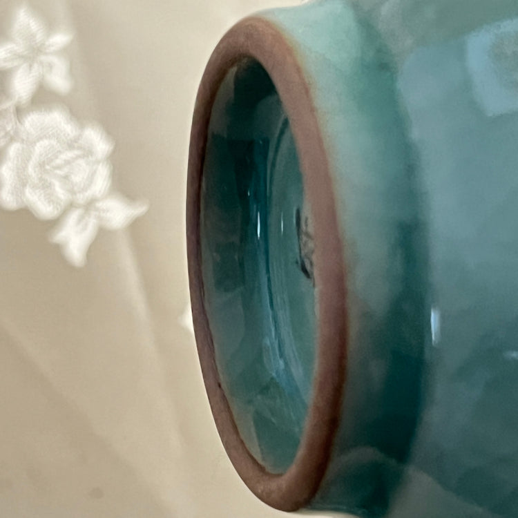 Close-up of a ceramic vase with a textured surface on a light background
