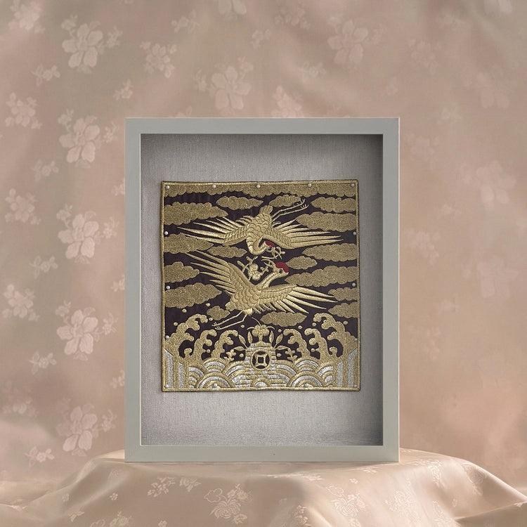 Decorative panel with a gold and black design of a bird on a floral wall background