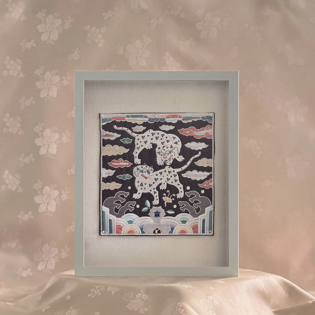 Framed artwork with a design of leopards on a floral wall background