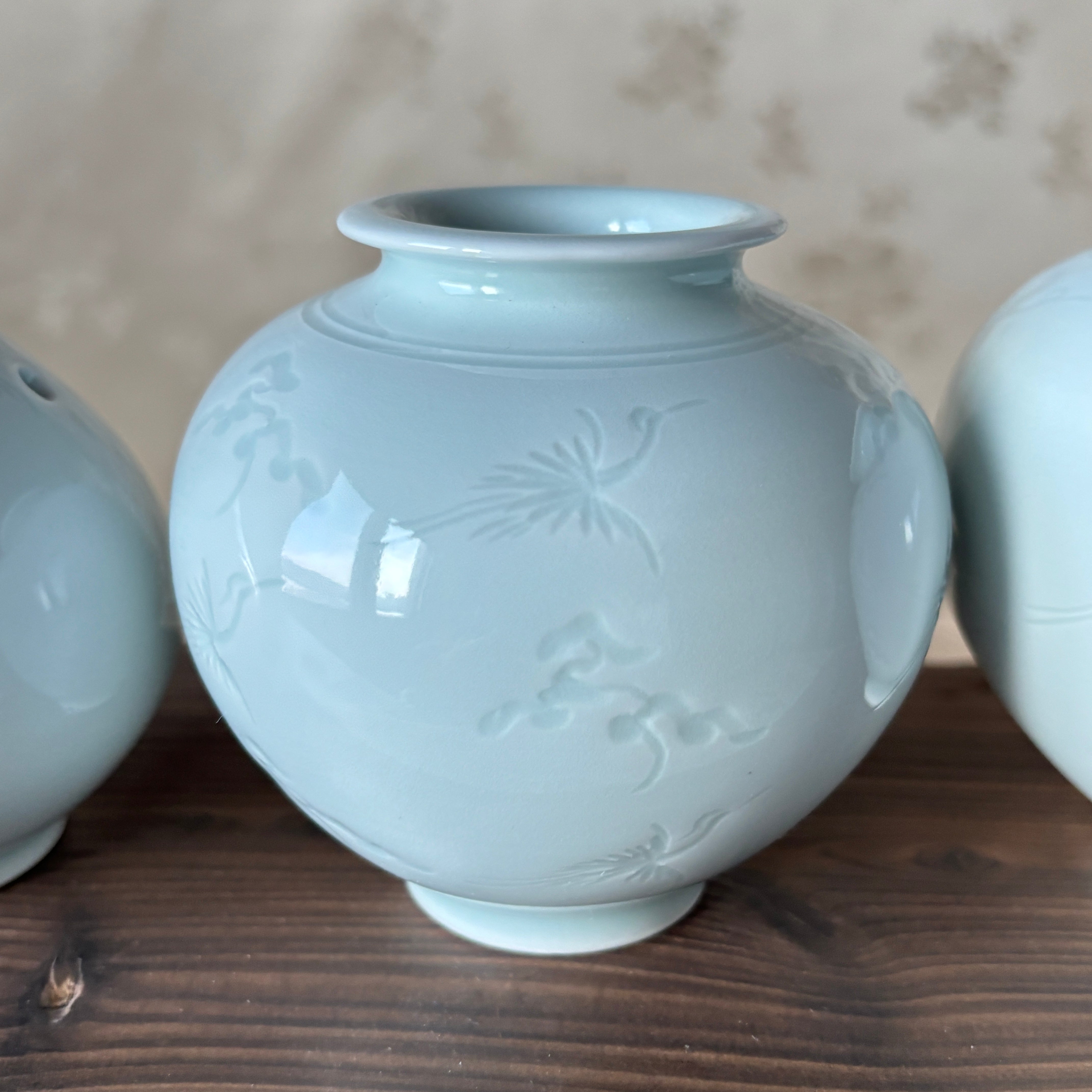 Ceramic vase with floral patterns on a wooden surface