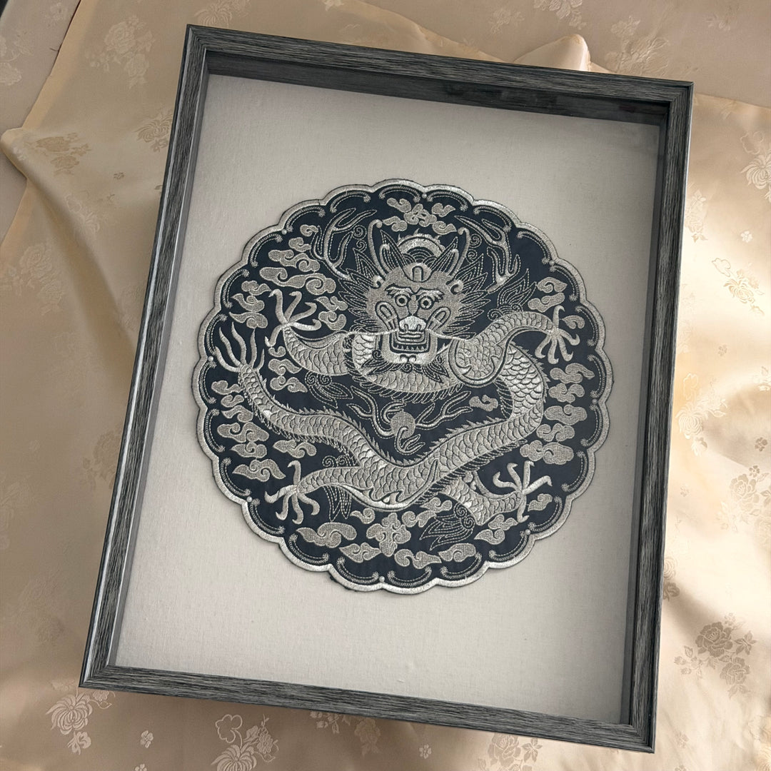 Framed artwork of a dragon design on a light background