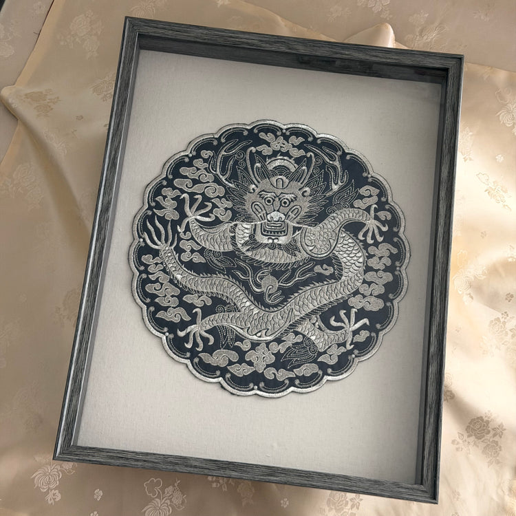Framed artwork of a dragon design on a light background