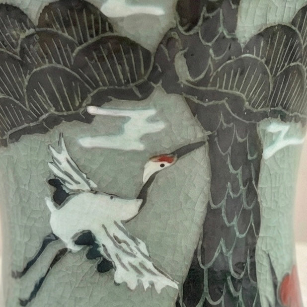 Decorative tile with a crane and peacock design on a textured background