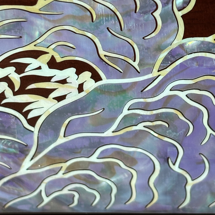 Decorative mother of pearl panel with abstract wave design in purple and white.